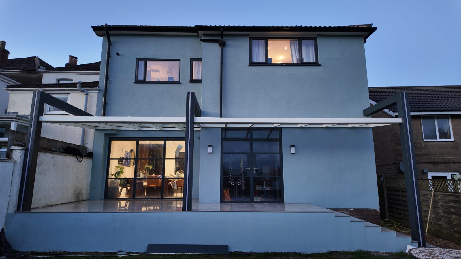 Anthracite DesignLine veranda at dusk with integrated LED lighting in the posts